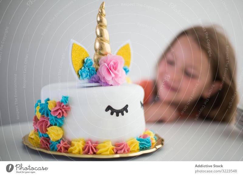 Bright unicorn cake for pleased girl at table party childhood bright happy little holiday birthday decoration celebrating cheerful fun kid festive funny cooking