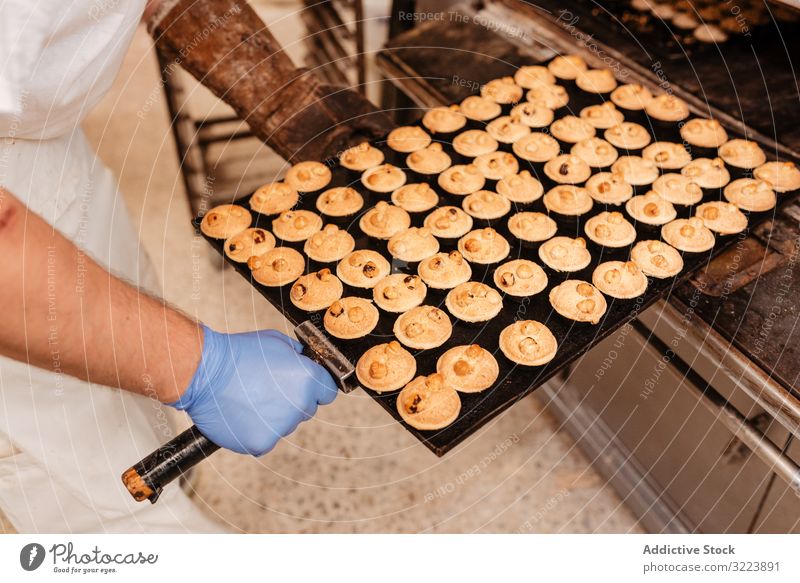 Bald baker checking pastry inside oven man bakery peek work confectioner cook hot process male adult uniform cuisine small business wait heat warm equipment