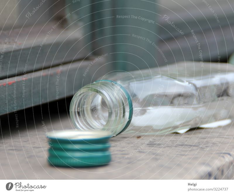 empty opened alcohol bottle lies on a wall Wall (barrier) Wall (building) Bottle Closure Cap Lie Authentic Small Gray Green Emotions Distress Lack of inhibition