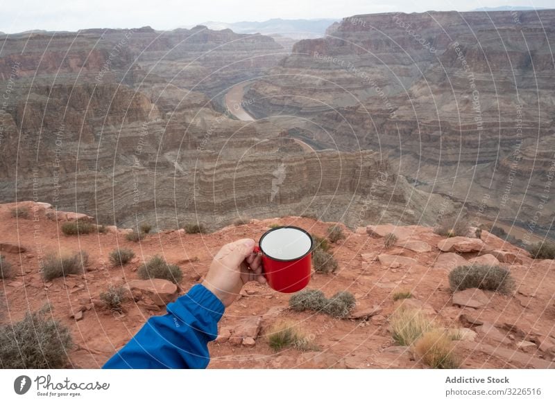 Male with cup of brew at rock man canyon cliff edge beverage relish break male usa nature travel landscape hiker terrain tourist grand park adventure national