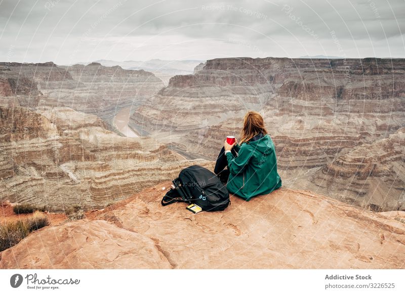 Female relaxing on cliff and admiring picturesque view woman canyon rest rock admire female tranquil jacket usa nature lifestyle hiking active sportswear sit