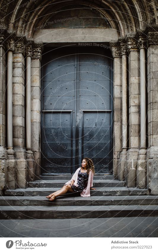 Lady resting near metal door on street tourist building woman old sit steps barcelona spain female relax lifestyle wanderlust traditional destination town