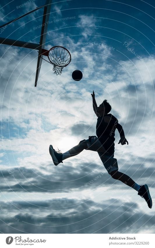 Young man playing on basketball court outdoor. athlete competition sports equipment adult recreation action portrait active activity asphalt athletic city drop