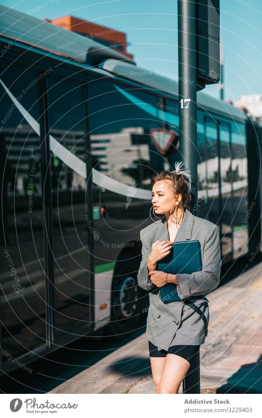 Woman with tablet in stylish suit standing nearby bus businesswoman using trendy communication manager career entrepreneur screen gadget device modern wireless