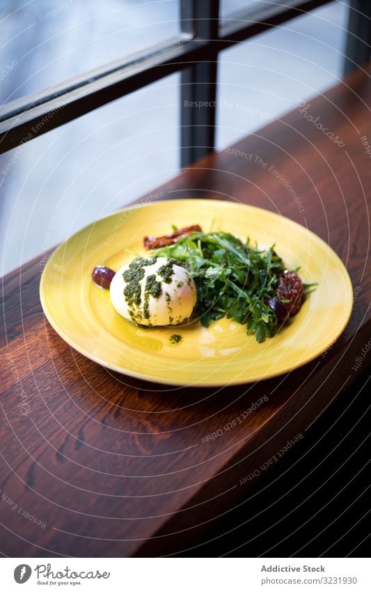 Yellow plate with healthy breakfast on wooden counter egg poached greenery food cafe served delicious meal sauce pesto gourmet fresh salad leaves white diet