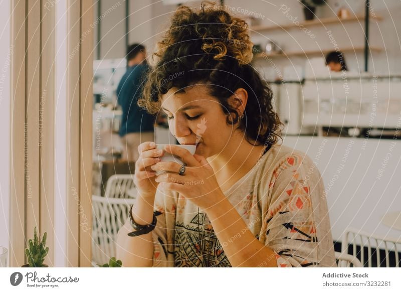 Positive woman drinking coffee in cafe positive happy smile sip mug modern joyful pleased cheerful coffee shop playful young adult hot drink beverage tea