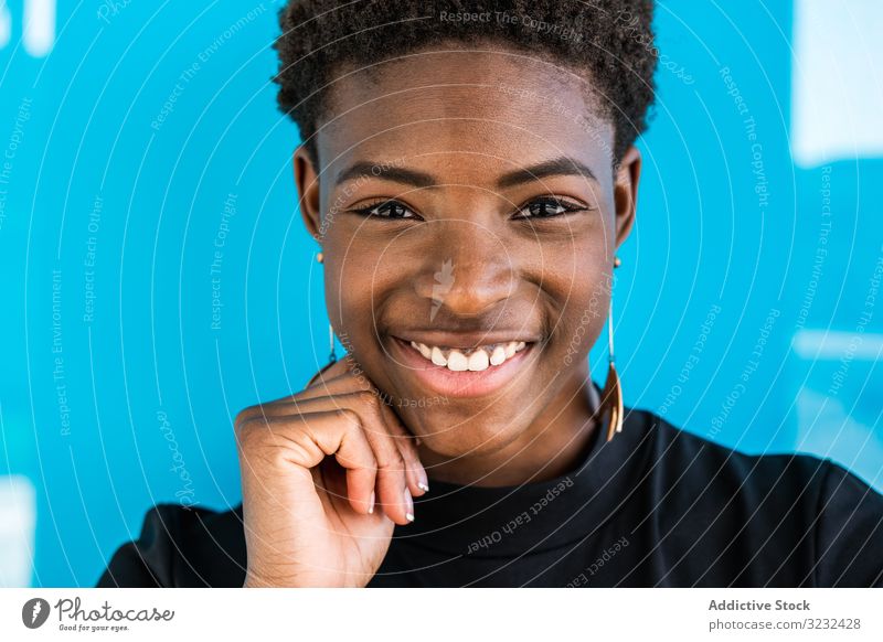 Black woman standing on blue background cool content female african american happy summer cheerful smile beauty style holiday young street attractive joy