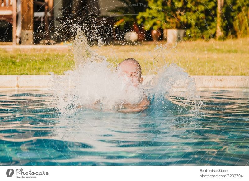 Cheerful girl jumping into pool water scream raised arms fun yard play kid child little hands up panties shirtless garden vacation weekend summer joy happy