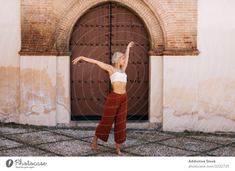 Young lady near old gate woman street ancient building folded arms closed eyes slim young tourism female travel trip aged exterior town city weathered grungy