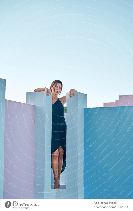 Woman standing on the top of a blue building woman casual elegant construction structure geometric architecture urban facade wall abstract exterior innovation