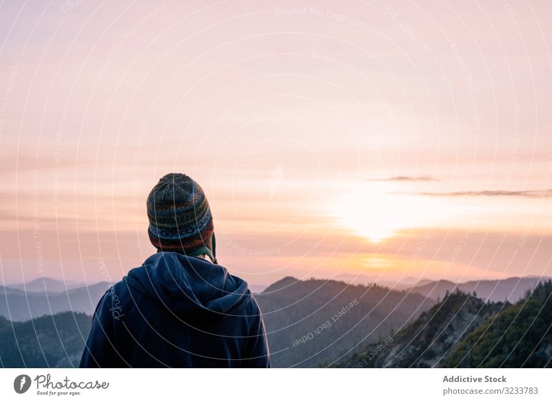 Warmly dressed person looking at sunrise in mountain tourist travel nature landscape sunset adventure tourism rock sky hike top beautiful vacation natural