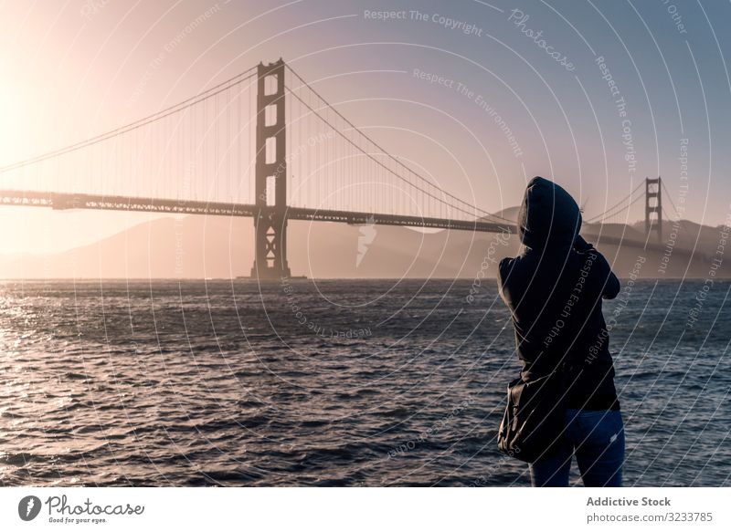 Tourist looking at ocean and large bridge in light day architecture water traditional travel tourist tourism river skyline transportation beautiful summer