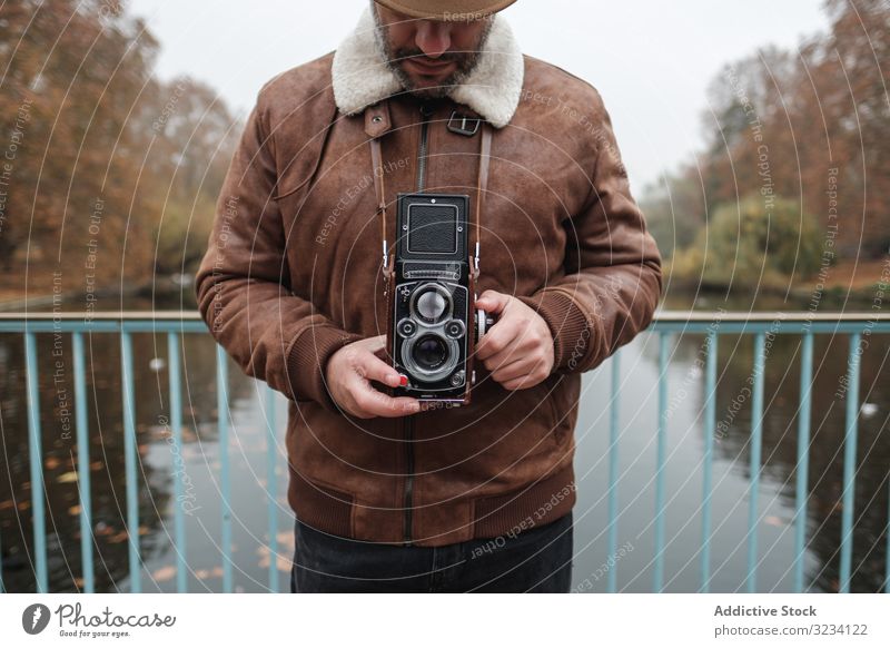 Male tourist with vintage camera near river STOCK photo camera park bridge man autumn calm london great britain travel water retro male device gadget check