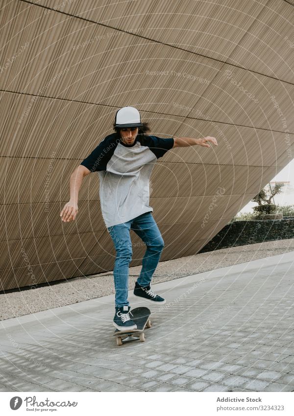 Sportive teenager riding skate on road along sloping wall man ride skateboard cool urban modern balance skater active exterior skateboarder practice freedom