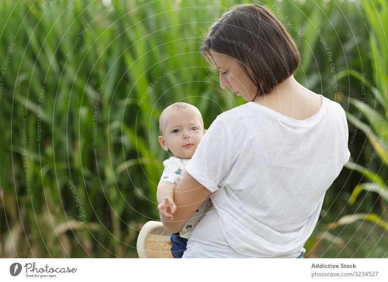 Adorable mother and child on hand enjoying and laughing in field family orchard parent happy fun together kid childhood little day cheerful motherhood joyful