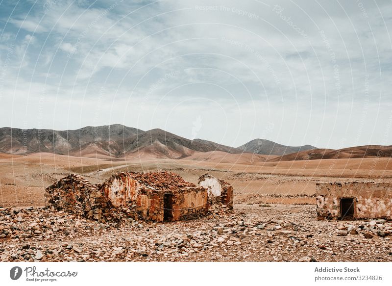 Dilapidated old buildings in mountain desert under cloudy sky house dilapidated ancient architecture stone shabby structure entrance amazing rustic exterior