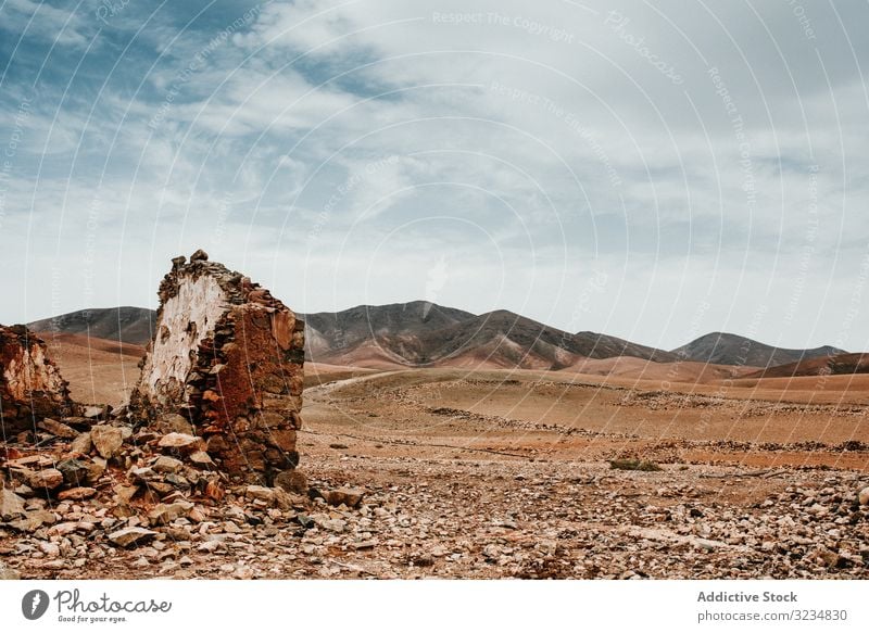 Dilapidated old buildings in mountain desert under cloudy sky house dilapidated ancient architecture stone shabby structure entrance amazing rustic exterior