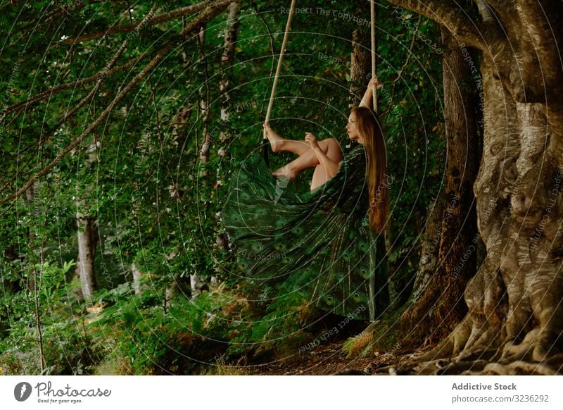 Affectionate topless woman swinging at trapeze in forest concept affectionate bare gorgeous slim long hair hanging swing bar tranquil woods blonde young adult