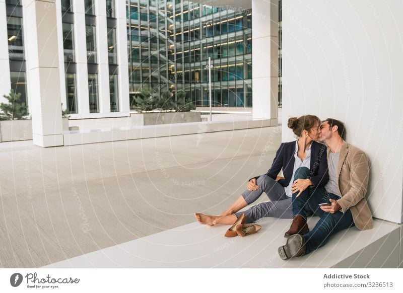 Businesspeople hugging and using smartphone on street businesspeople couple social media building sit rest city together man woman manager entrepreneur casual