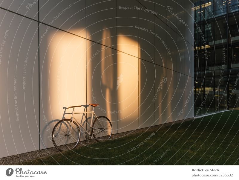 Bicycle parked outside modern building bicycle street city sidewalk urban transport exterior contemporary downtown commute structure construction pavement path