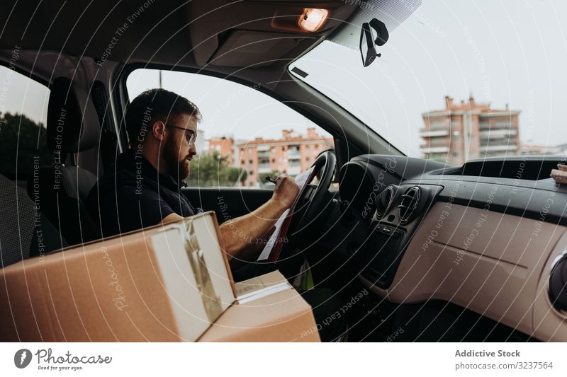 Courier preparing cartons for express delivery man courier write box pensive check marker street prepare order service attentive job distribution package male