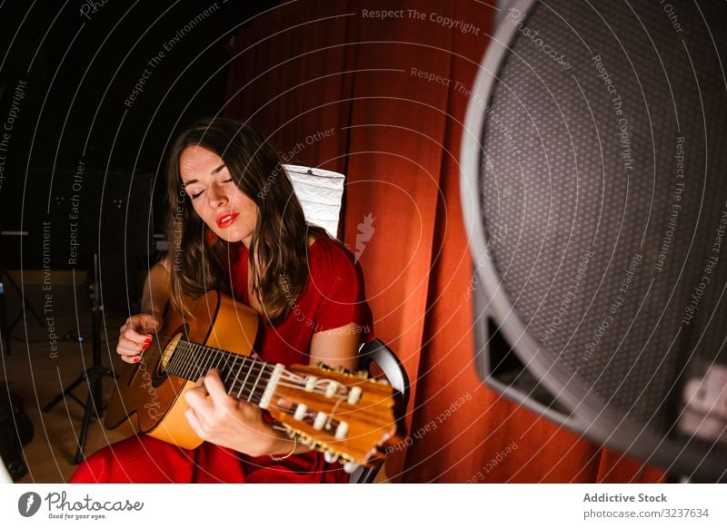 Creative woman singing and playing guitar on stage performance music musician singer guitarist concert performer entertainment sound artist instrument player