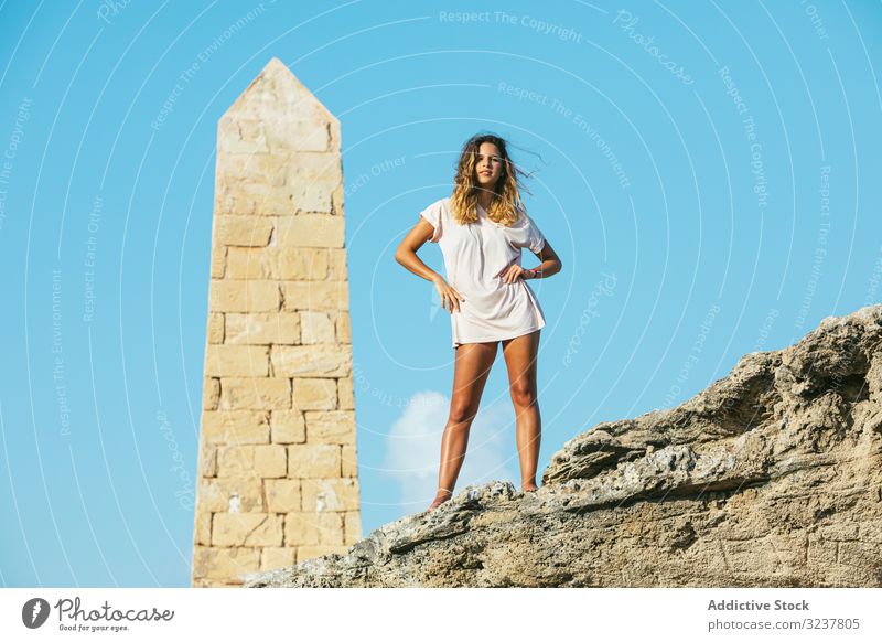 Stylish young woman on vacation getting on top of cliff tourist standing obelisk adventure traveler mountain rock extreme hiker freedom valley activity nature