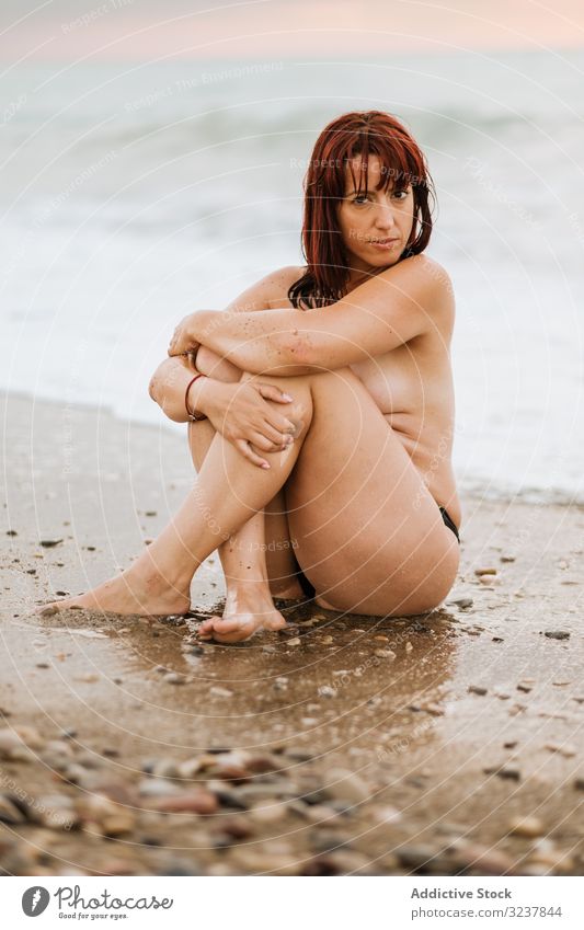 Young Beautiful Naked Woman Posing on a Stone Near the Sea Stock