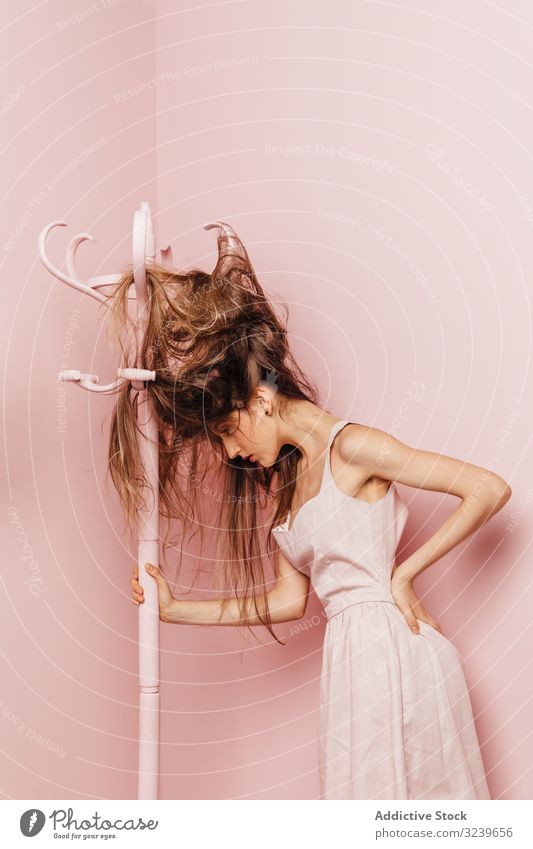 Teen girl with tangled hairs clothes rack indoor pink annoyed girl frustrated female angry woman single difficulties nervous damaged desperate expressive casual