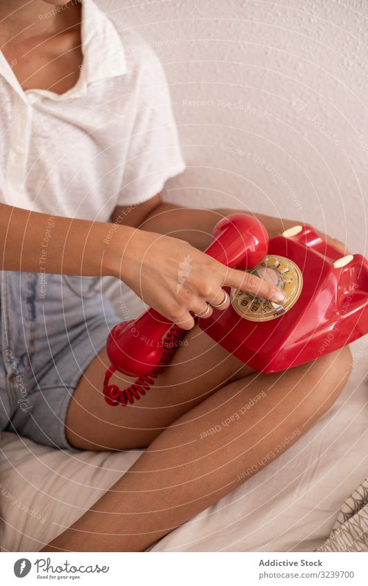 Crop woman hanging up telephone hang up handset end conversation bed rest lying home female comfort cozy retro vintage red apartment flat blanket relax lady