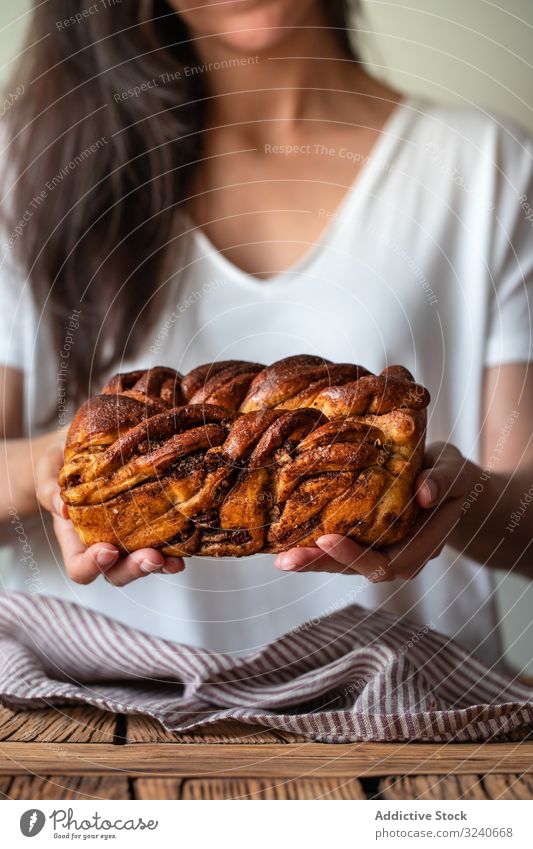 Faceless woman with appetizing cinnamon babka cook bread dessert baked twisted loaf delicious food sweet homemade fresh chocolate cuisine female white t shirt