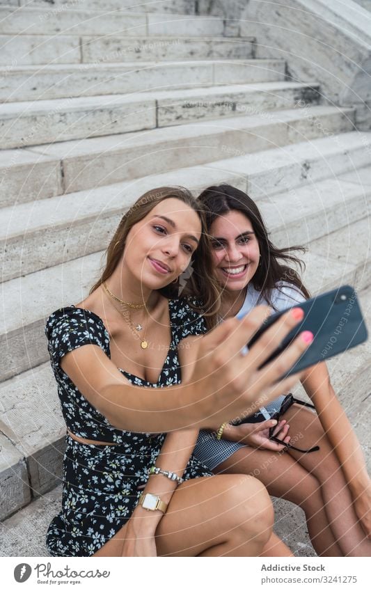Laughing women taking selfie on stairs at old building travel architecture smartphone using dome budapest shape social media friend friendship relationship