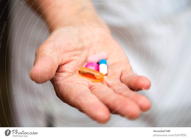 Many multi-colored pills in a Senior's hands. Painful old age. Bottle Health care Medical treatment Illness Medication Hospital Human being Woman Adults Hand