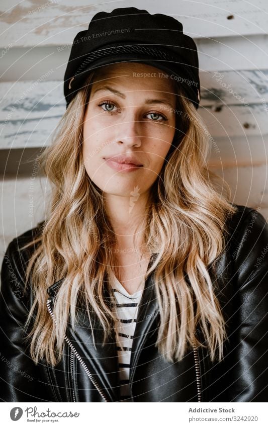 Beautiful blonde woman stylish pensive natural trendy contemplate curly female long haired beauty leather jacket attractive alone casual cap hat romantic