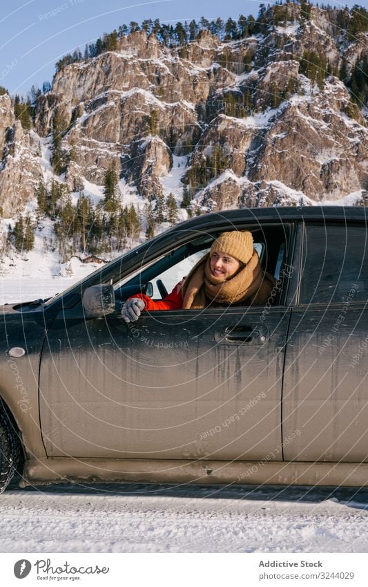 Woman leaning out car window on snowy valley woman mountain winter siberia road trip happy enjoy smile nature scenery rock hill cold landscape scenic russia