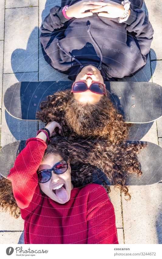 Two young skaters resting with the heads on their boards Lifestyle Style Joy Happy Leisure and hobbies Board game Summer Sports Human being Feminine Young woman