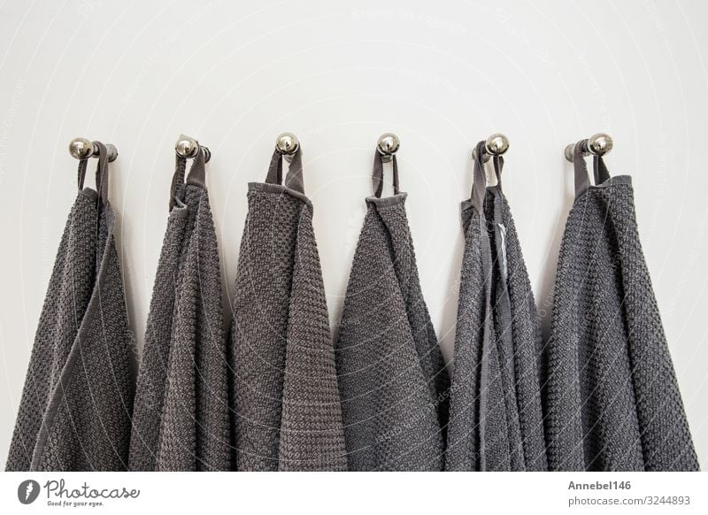 Grey towels hanging in a row, prepared on hanger. white wall Spa Vacation & Travel House (Residential Structure) Bathroom Cloth Metal Steel Clean Soft Gray