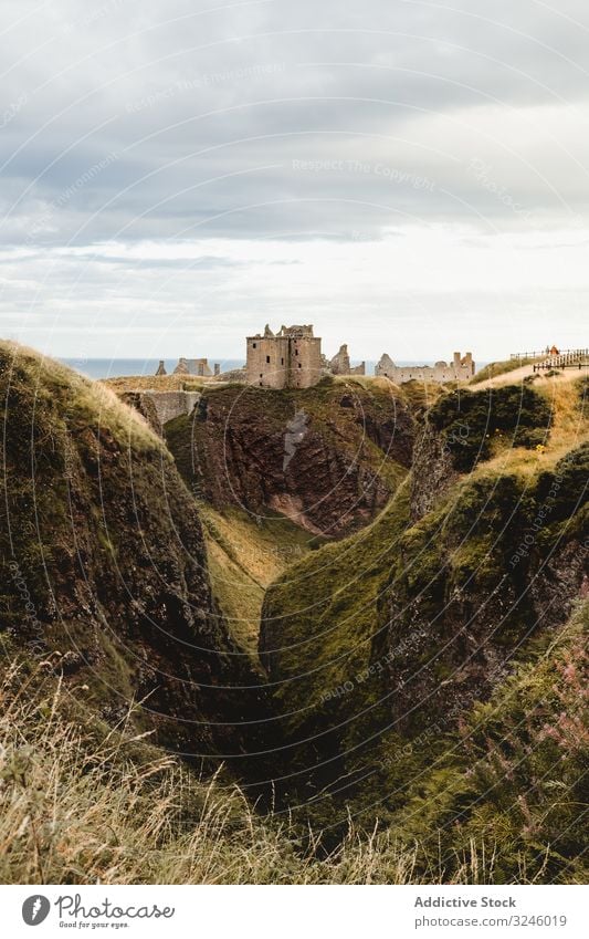 Scottish landscape with hills and medieval buildings ravine scotland mountain highland travel scottish summer sky cloudy tourism nature adventure vacation stone