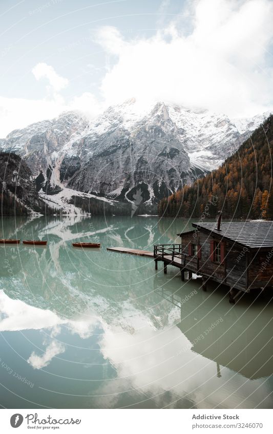 House on stilts on lake near mountains house boat wooden reflection nature travel water landscape sky scenery view tourism vacation clouds holiday adventure