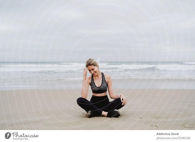 Woman meditating on the beach woman yoga practice sea ocean female exercise balance training workout young athlete active calm tranquility sportswear body