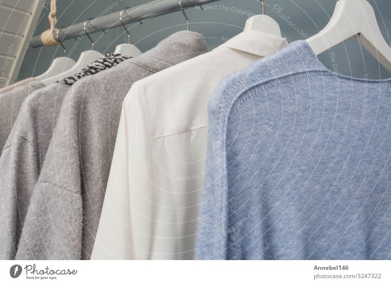 https://www.photocase.com/photos/3247322-clothes-hang-on-a-a-clothing-rack-white-gray-and-blue-photocase-stock-photo-large.jpeg