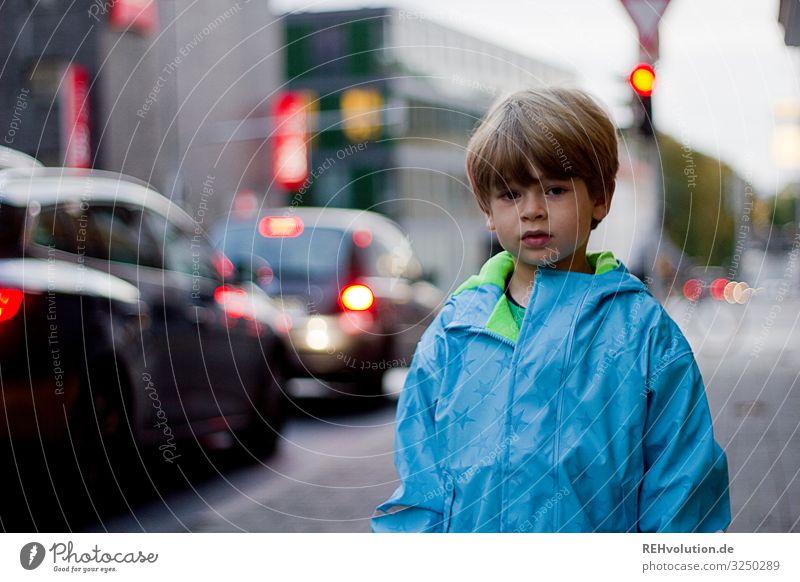 Child standing on a street Street Road traffic Traffic light Transport Town Boy (child) peril Responsibility way to school Going Traffic infrastructure