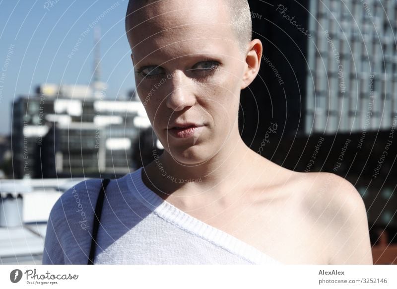 Portrait of a young, bald woman standing on a roof in Hamburg, so that you can see the skyscrapers of Hamburg in the background. pretty Life Young woman