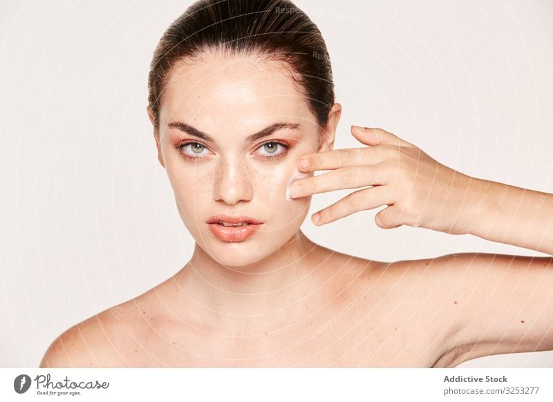 Woman Wrapped with Bath Towels, Applying Cream on her Face Stock