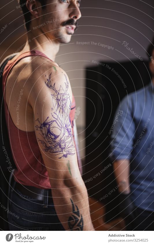 Man Looking At Tattoo Sketch On Arm In Salon A Royalty Free Stock Photo From Photocase