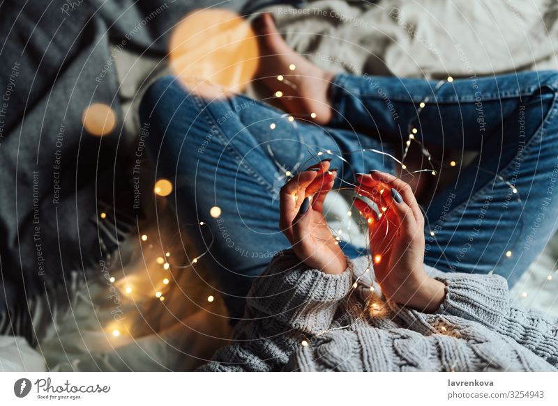 Woman sitting in her bed with Christmas fairy lights Bed Bedclothes Blur Caucasian Christmas & Advent Comfortable Denim Faceless Fairy lights Hand Home hygge