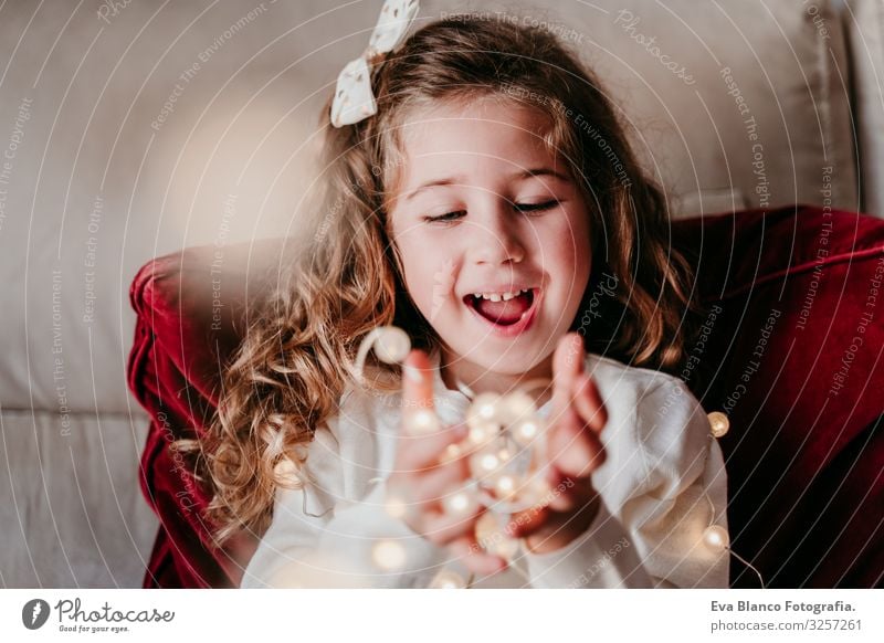 beautiful kid girl at home playing with garland of lights. Christmas concept Christmas & Advent Light Paper chain Home Blonde blue eyes Child Love Together
