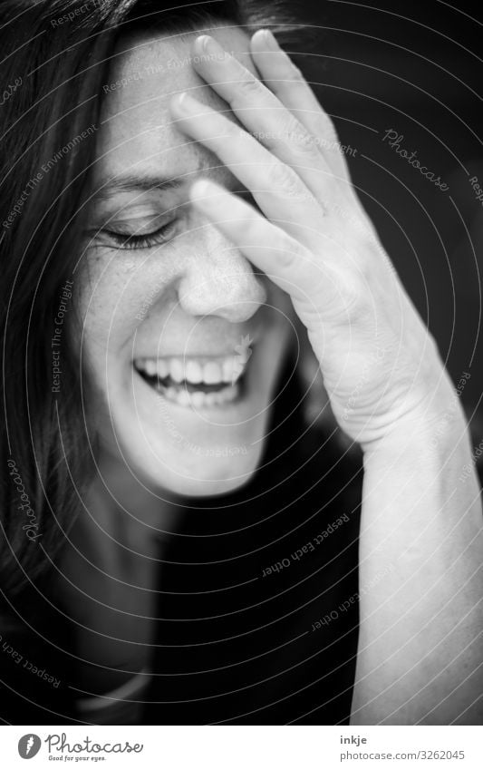 laughing woman with closed eyes and hand on forehead Black & white photo Interior shot portrait Close-up portrait of a woman shut eyes Laughter cheerful Amused
