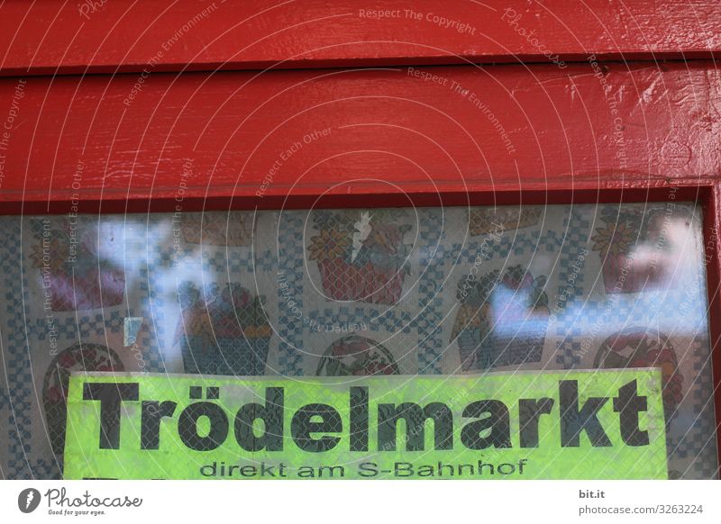 Black, thick lettering: flea market, written on sign in neon, hangs in old window, with red frame and nostalgic curtain, behind the window pane, as advertisement, hint, announcement, program for a flea market at the S-Bahn station in the city.