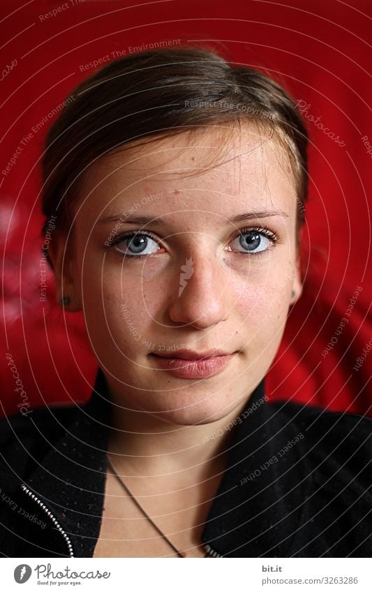 Young woman, girl, teenager with make-up, smiling, in front of a red background looking forward into the camera. Human being Feminine Youth (Young adults) Head